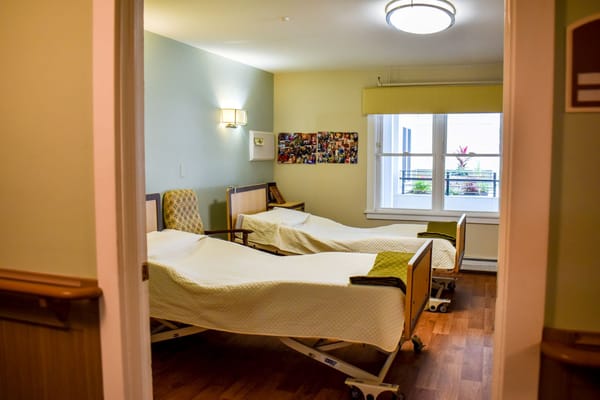 Two adjustable beds in a resident room with natural light