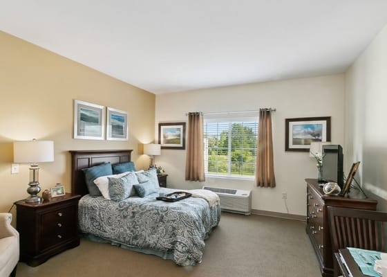 Well-furnished bedroom with a bed, nightstand, and window