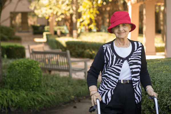 Resident in a red hat enjoying the outdoor garden