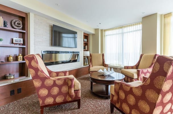 Comfortable seating in a bright living room with a fireplace and bookshelves