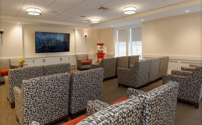 Comfortable lounge with patterned chairs and a popcorn machine