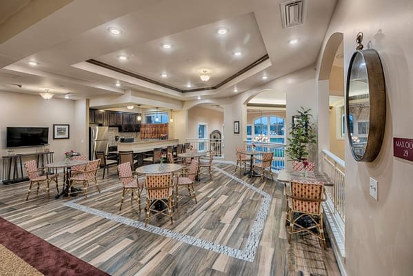 Cozy lounge area with dining tables and a kitchen in the background