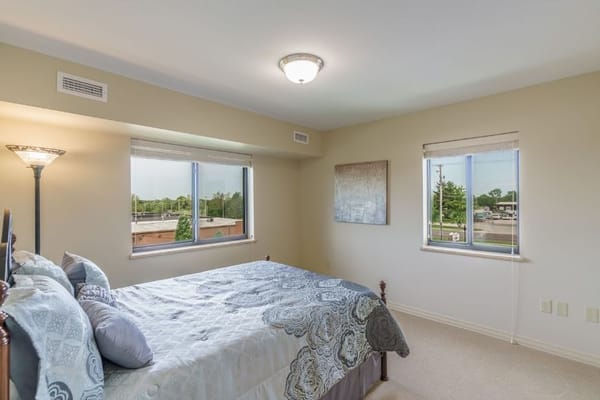Brightly lit bedroom with twin beds and windows