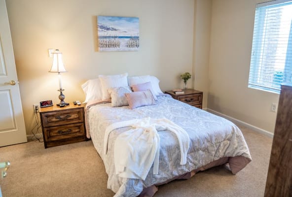 Cozy bedroom with a bed, nightstand, and window.