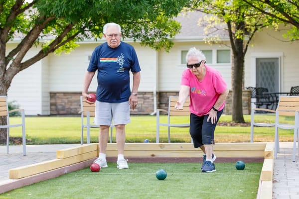 Two seniors playing bocce ball outdoors at Touchmark at Meadow Lake Village.