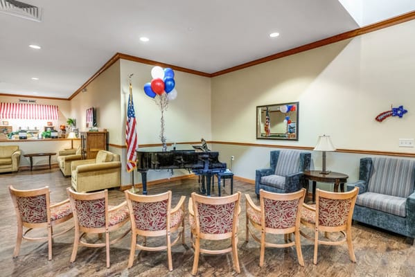 Cozy lounge area featuring seating, a piano, and American flag decor.