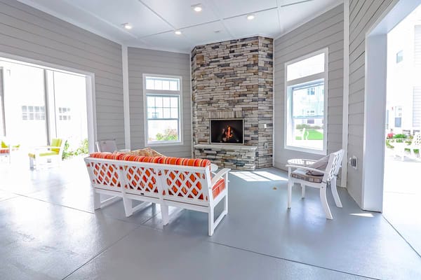 Bright indoor common area with a stone fireplace