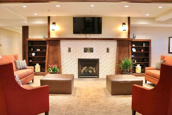 Comfortable lounge seating with a fireplace and shelves.