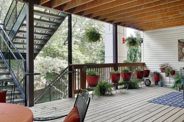 Outdoor porch area with hanging plants and spiral staircase