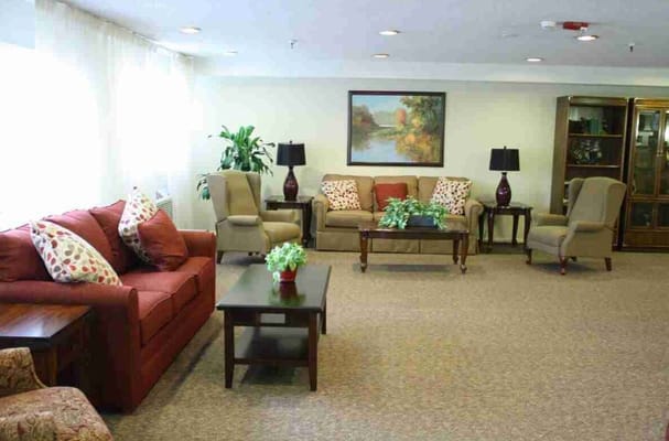 A warm and inviting living room with seating areas and decorative plants.