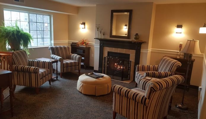 Cozy living area with striped chairs and a fireplace