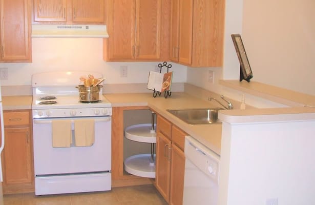 Compact kitchen with white appliances and wooden cabinets