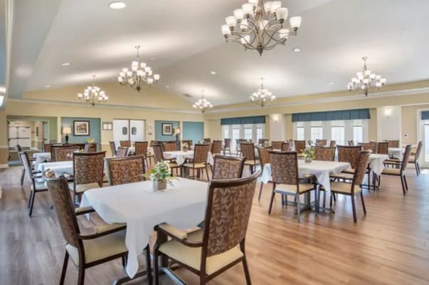 Bright dining room with tables and chairs set up.