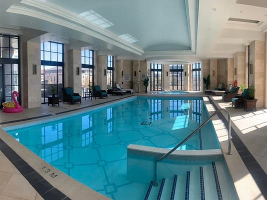 Indoor swimming pool area with seating and plants