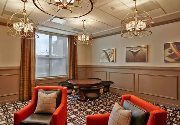 Cozy seating area with red chairs and wooden table in Wellbrooke of South Bend.