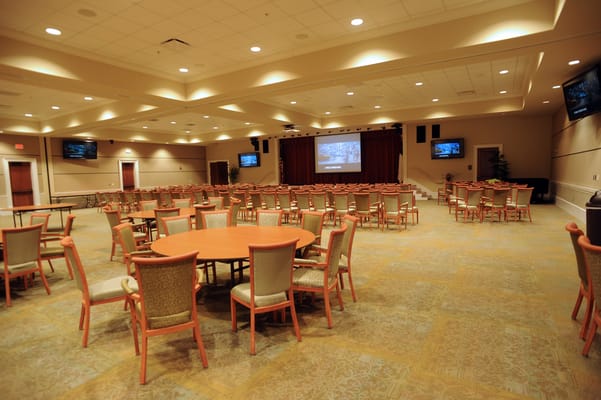 Empty activity room with tables and chairs arranged