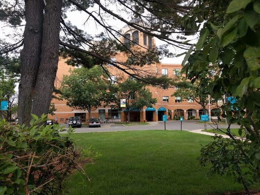 View of Youville House with green grass and trees in the foreground.