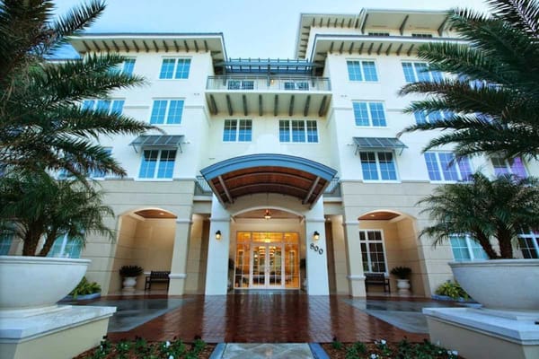 Exterior view of an assisted living facility with palm trees