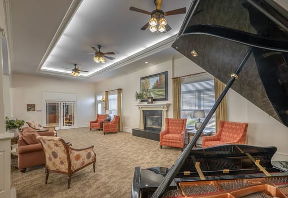 A bright common area with seating and a piano