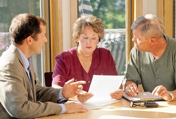 Three individuals engaging in a discussion indoors