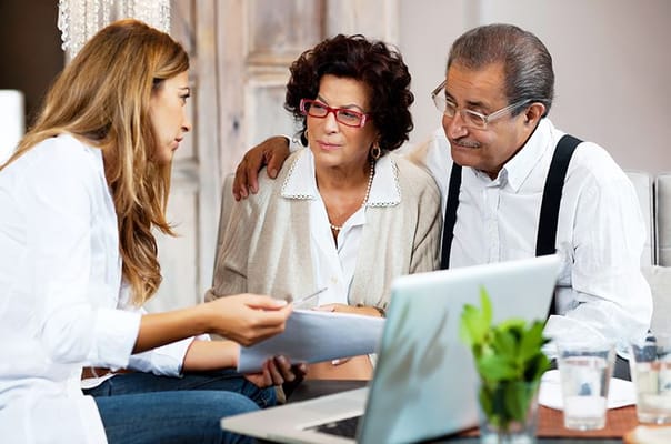 Two seniors and a staff member discussing paperwork
