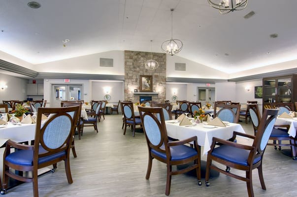 Spacious dining room with elegantly set tables and a fireplace