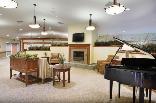 Bright lounge area with seating and a piano