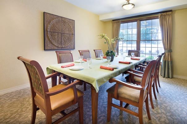 A dining room with a large table set for a meal
