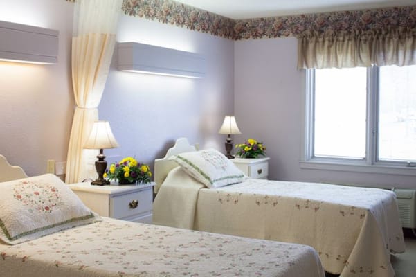 Cozy twin-bedroom setup with floral decor and lamps