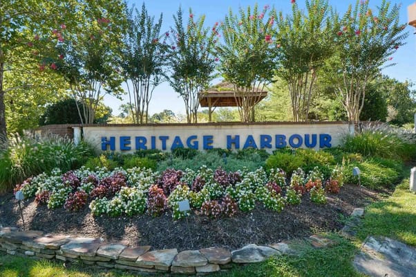 Sign for Heritage Harbour surrounded by flowers