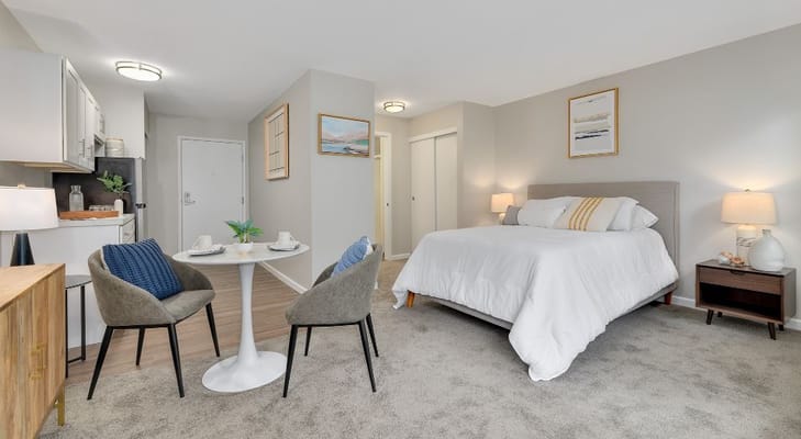 Spacious bedroom with a bed, table, and seating area.