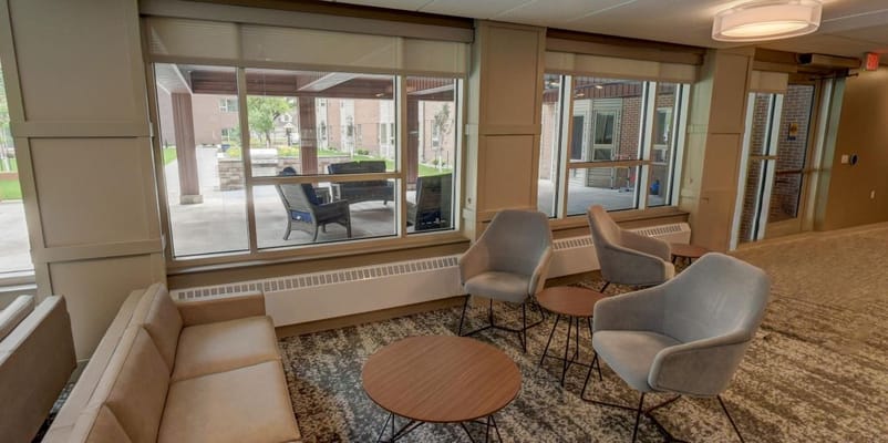 Lounge seating area with large windows in Eventide Linden Tree Circle
