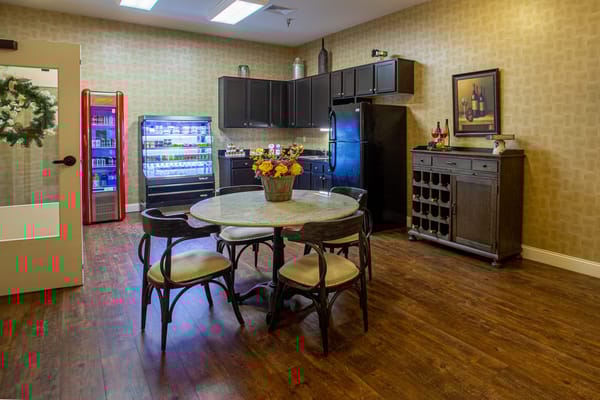 Kitchenette with dining table, refrigerator, and snack area