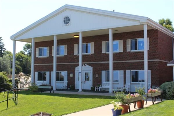 Exterior view of a senior living facility with seating areas