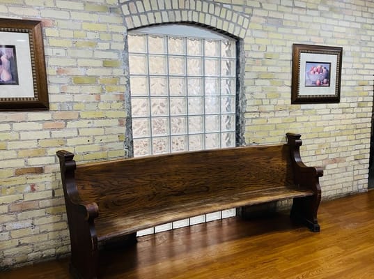 Wooden bench against a brick wall with art