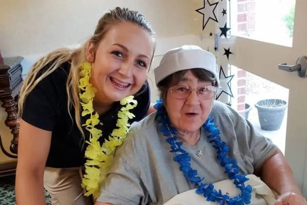 Staff member and resident celebrating with leis