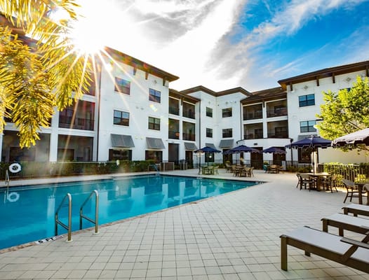 Outdoor pool area with sun loungers and umbrellas