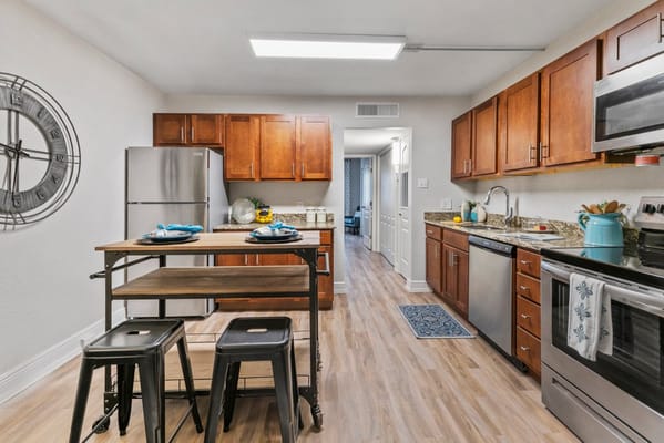 Modern kitchen area with wooden cabinets and appliances