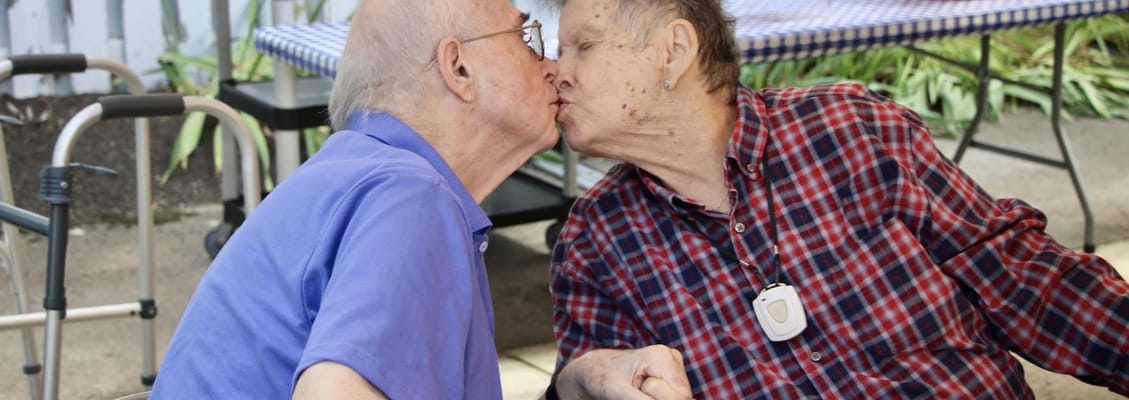 Two residents sharing a affectionate kiss outdoors