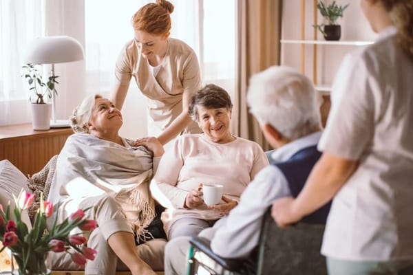 Care staff interacting with residents in a cozy lounge