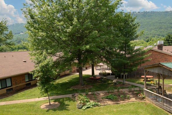 Outdoor view of the facility grounds with trees and seating areas