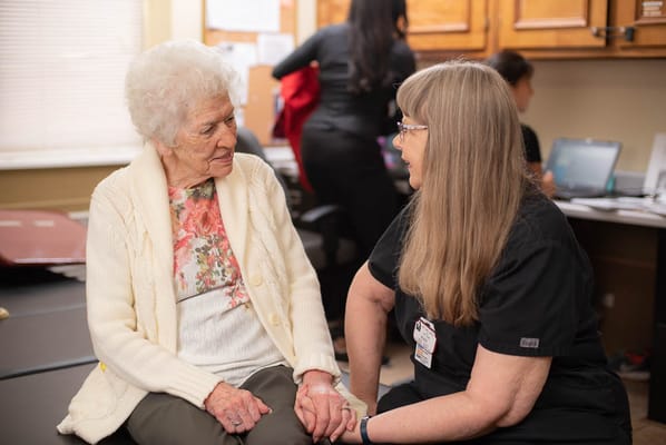 Staff member engaging with a resident in an interior setting
