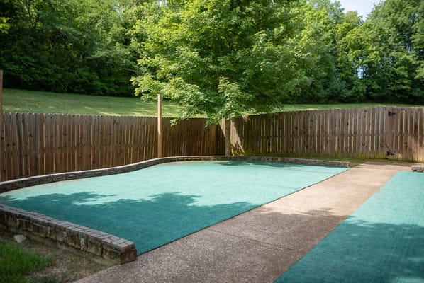 Outdoor space with a green surface and trees