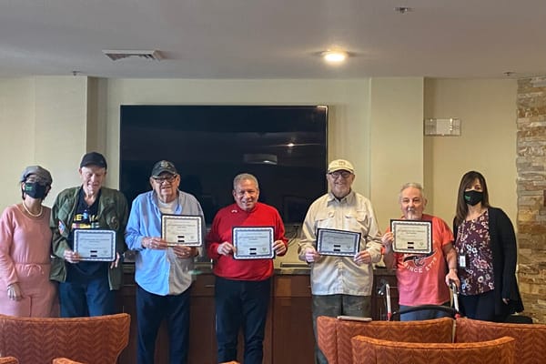 Residents celebrating with certificates in a common area