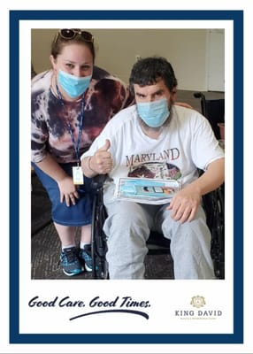 Resident and staff member posing with a thumbs-up