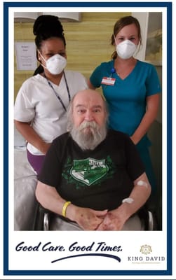 Two staff members with a resident in a care setting