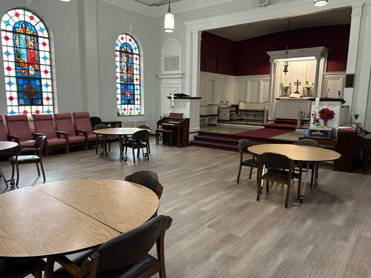 Interior view of a spacious common area with stained glass windows