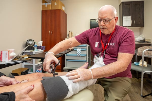 Staff member assisting a resident with leg treatment