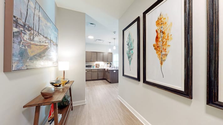 Interior hallway with art and kitchen visible