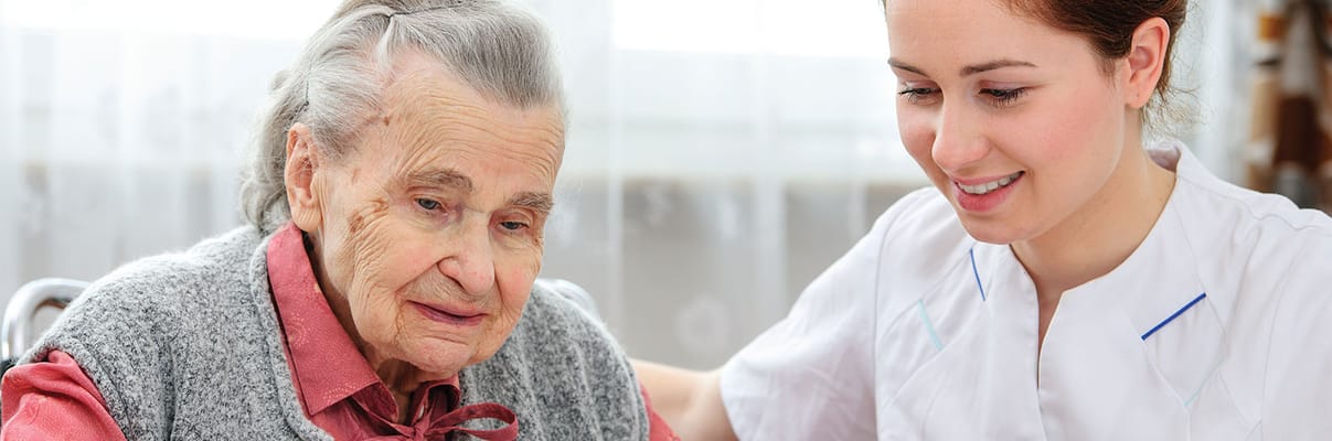 Caregiver interacting with a resident in a bright room